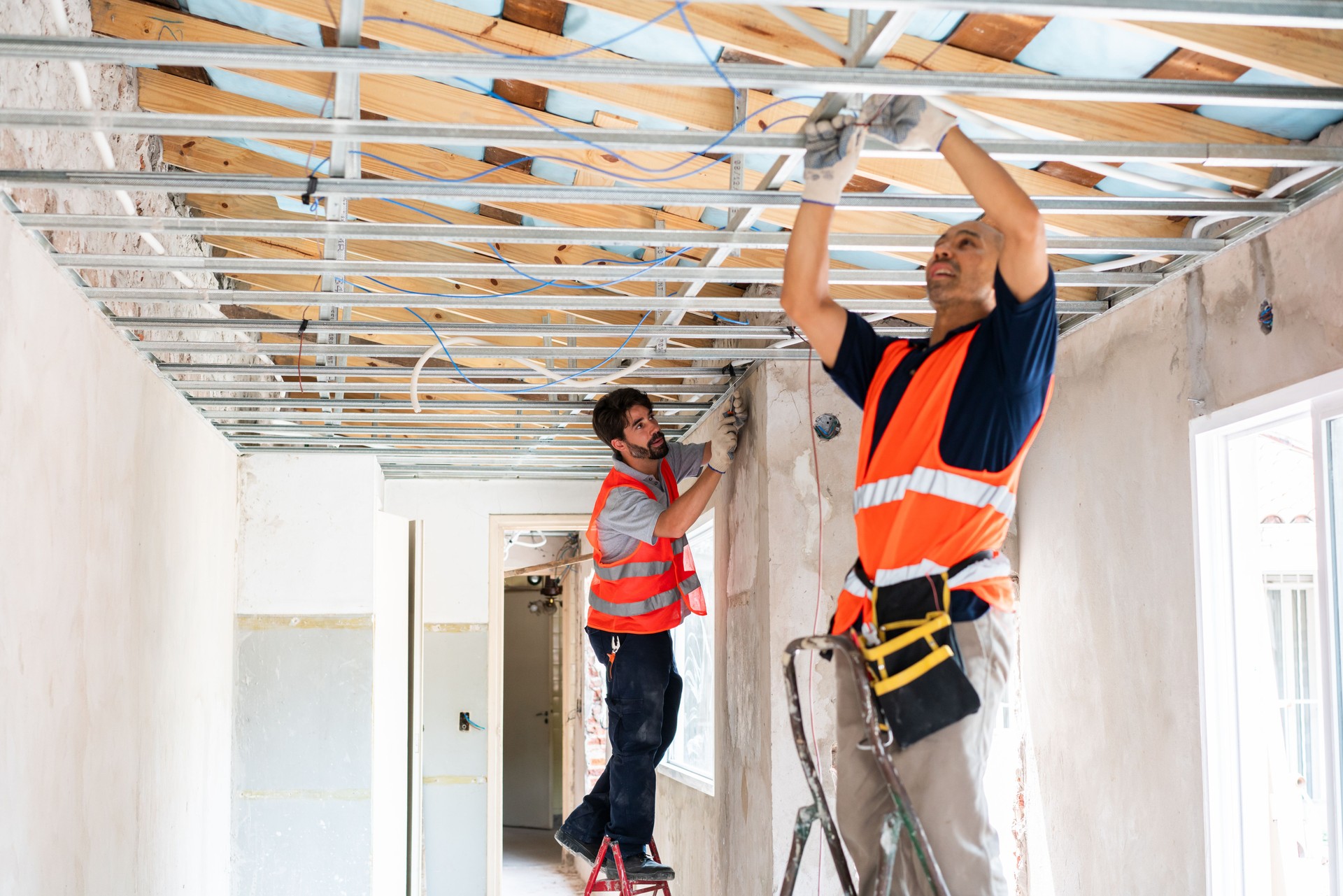 Construction Workers Installing Ceiling Fixtures on Site