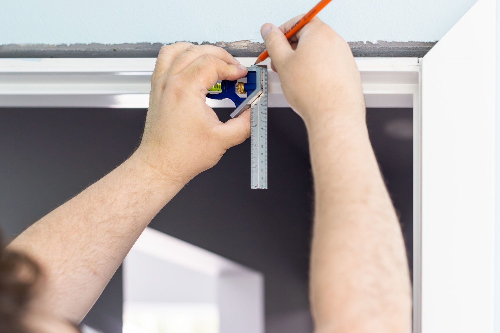 A man is making measures for door trims installation