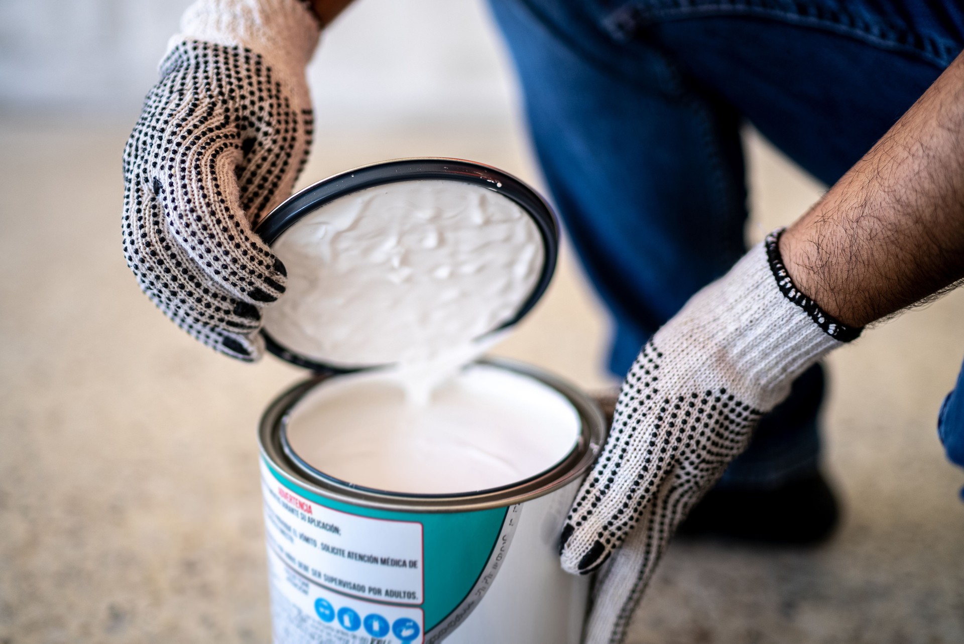 Construction worker opening paint can indoors